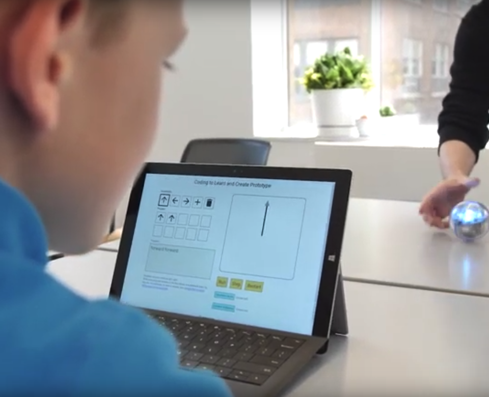 Image of a kid using an early version of Weavly on a laptop to control a Sphero robot